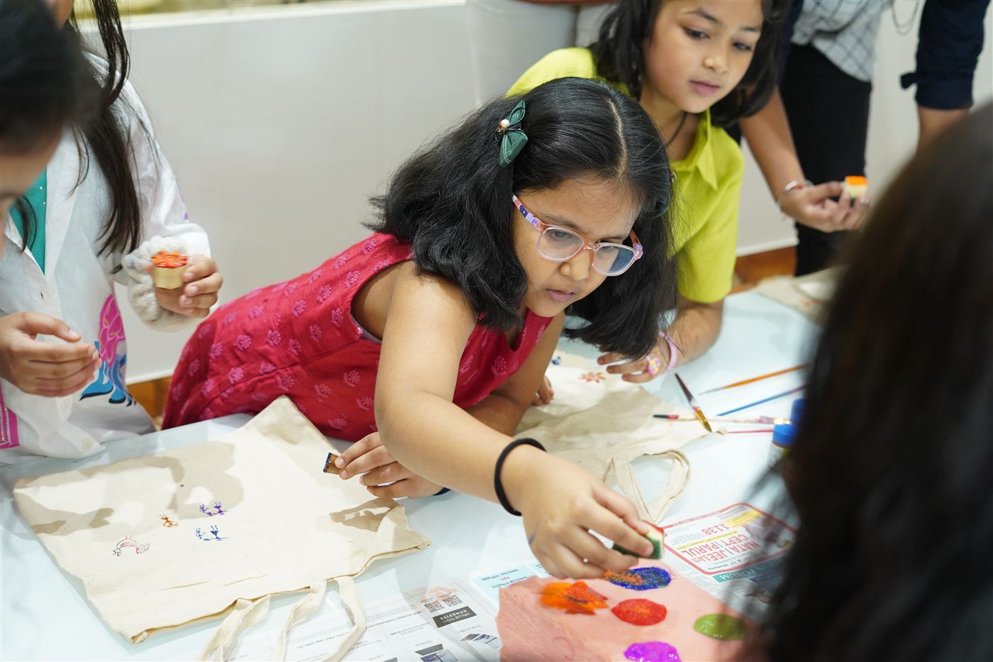 A girl block-printing a tote bag